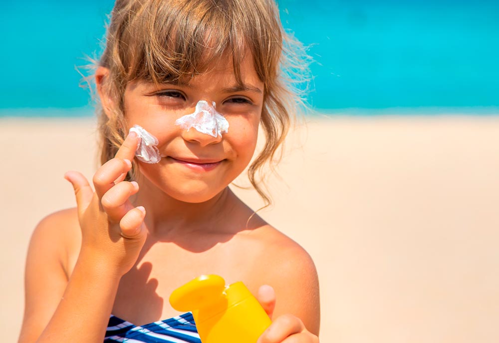 niña aplicándose crema en la cara